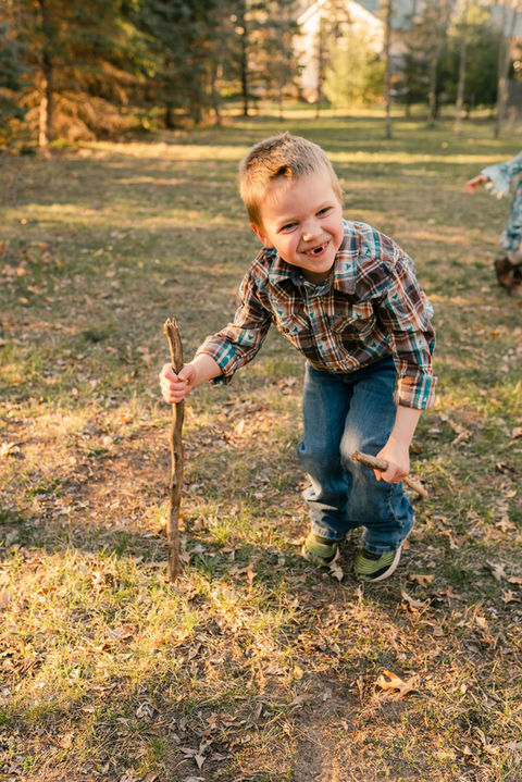 boy in plaid pretending to be an old man with a walking stick