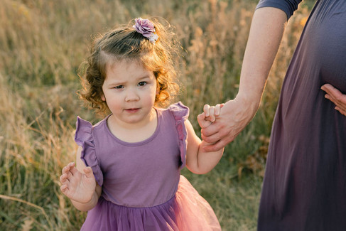 girl holding pregnant mom's hand