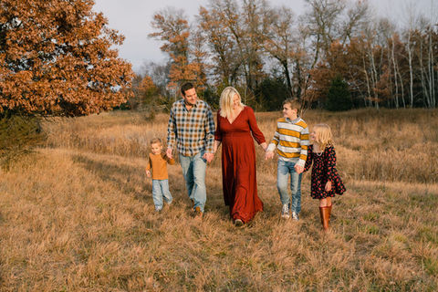 family of 5 walking in a line in their backyard