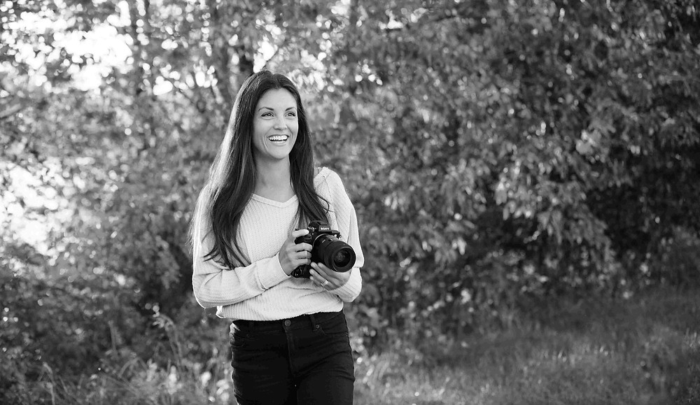 Maple Grove photographer holding camera in hand at a park in Minneapolis