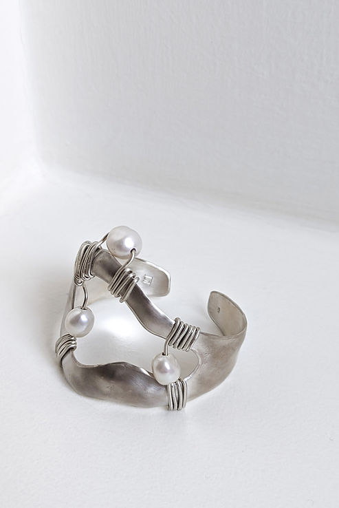 Hand crafter silver and pearl cuff on a white background