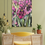 Thumbnail: an original artwork by Violett Grant featuring an abstract style trio of purple irises in texture, on a light green wall above a small desk and a yellow chair.