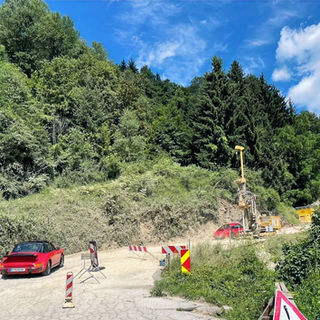 two red Porsche 911 driving thru road construction