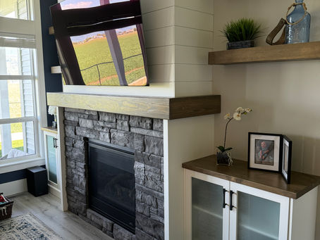 Living room fireplace with mantel and cabinets
