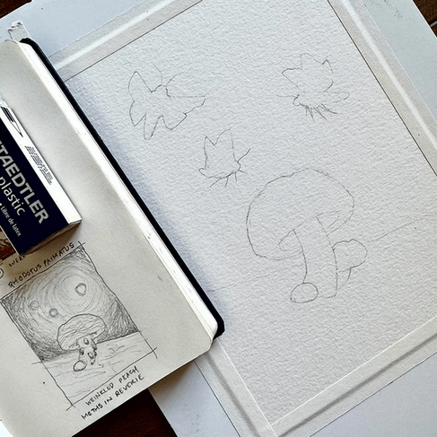 Prepped sheet of watercolor paper with a rough sketch of what is shown in the open sketchbook next to it