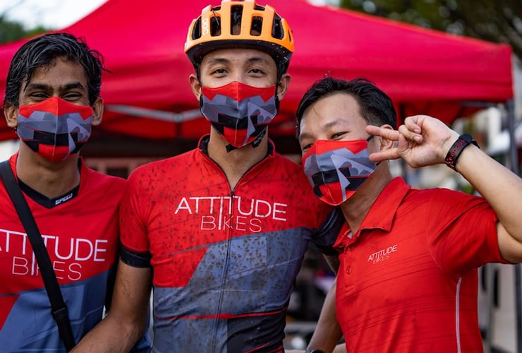 Une équipe mixte célèbre après avoir franchi la ligne d'arrivée d'une course à obstacles, couverts de boue mais souriants.