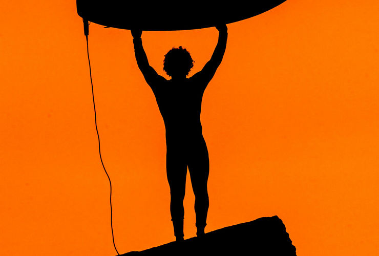 Une personne effectue un salto arrière sur un trampoline dans un parc intérieur, capturant l'énergie et le plaisir de l'acrobatie.