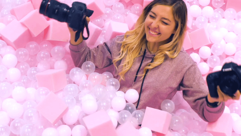 Gaby taking photos with a pink background