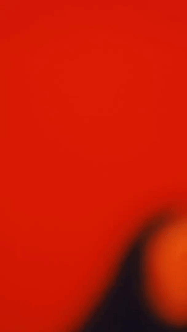 A model posing in front of a red background.=
