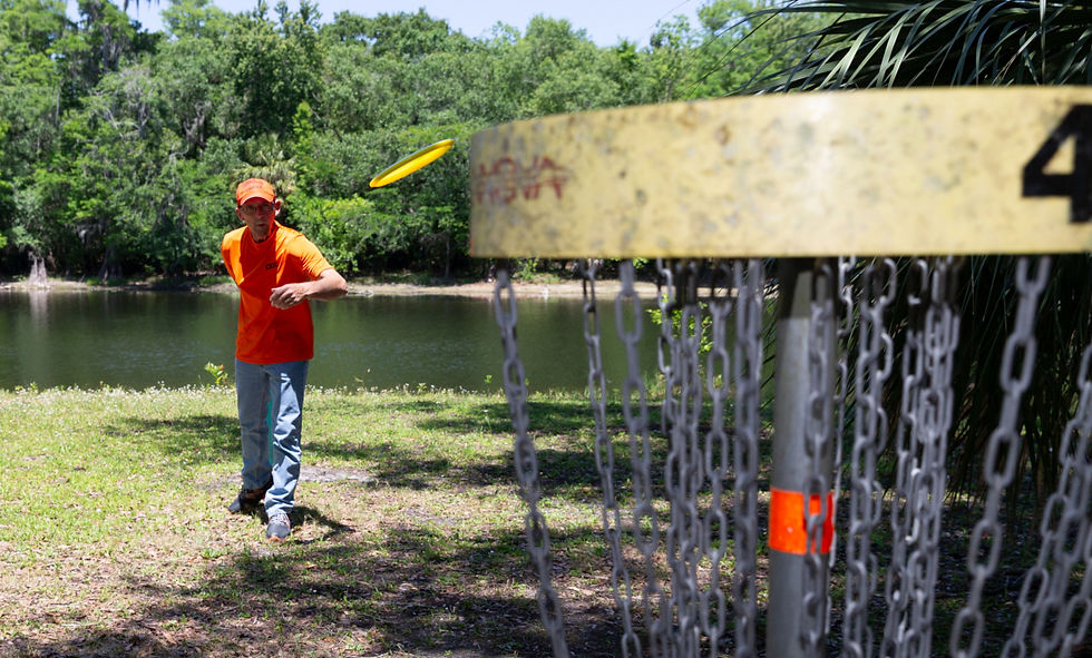 Eric Bilow watches as his disc heads toward the goal on a disc golf course near where doctors treated his cancer.