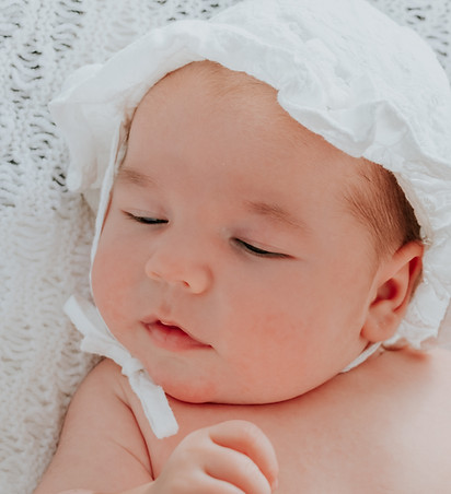 Newborn baby wearing a white hat