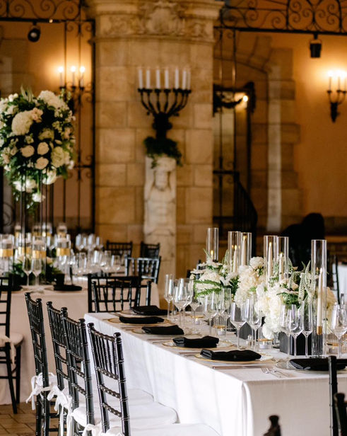 Long banquet table with white florals and candles at a Fort Lauderdale wedding.