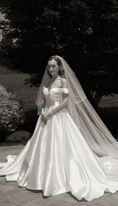 bride in wedding gown standing outdoors with natural bridal hair and makeup