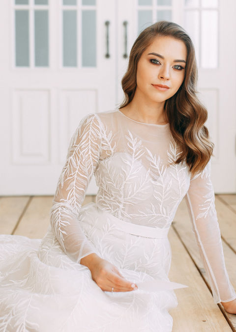Bride with soft long waves wearing a lace wedding dress