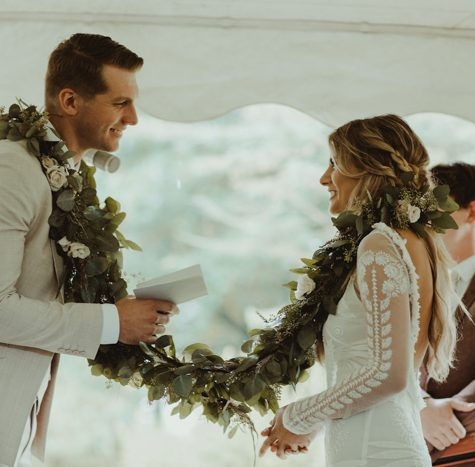 Bride and groom standing together during ceremony exchange with elegant bridal styling.