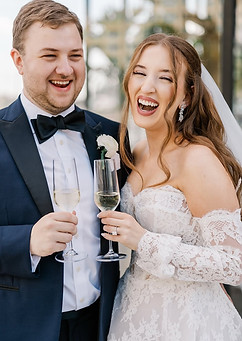 bride and groom laughing sipping champagne