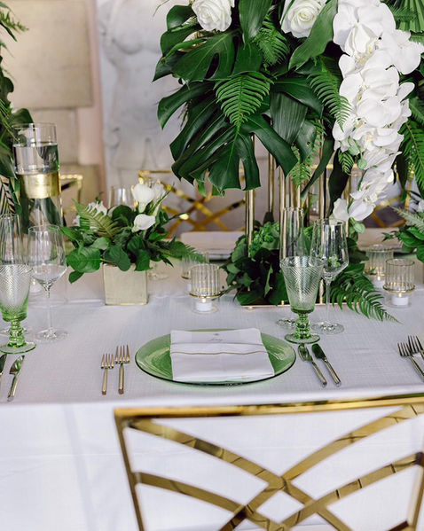 Green and white reception table setting with candles and crystal glassware.