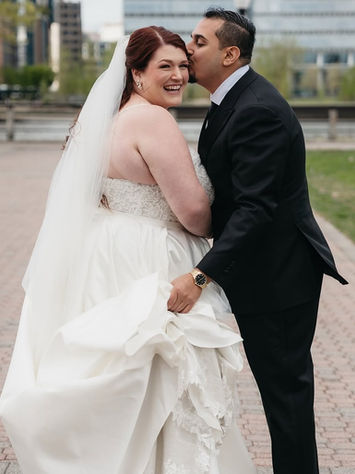 bride and groom smiling together outdoors with flowing wedding dress