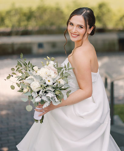 bride holding bouquet with soft bridal makeup and elegant hairstyle