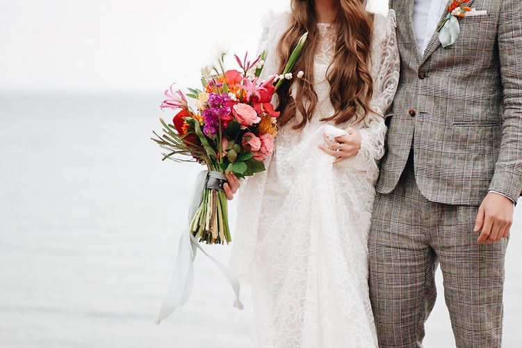 midsection-wedding-couple-standing-beach.jpg
