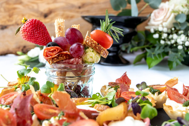Rustic charcuterie jar with cured meats, fruit, and artisan bites for wedding catering.