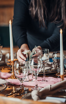 Rebecca, founder of Servers With a Smile, styling glassware and candles during event setup.