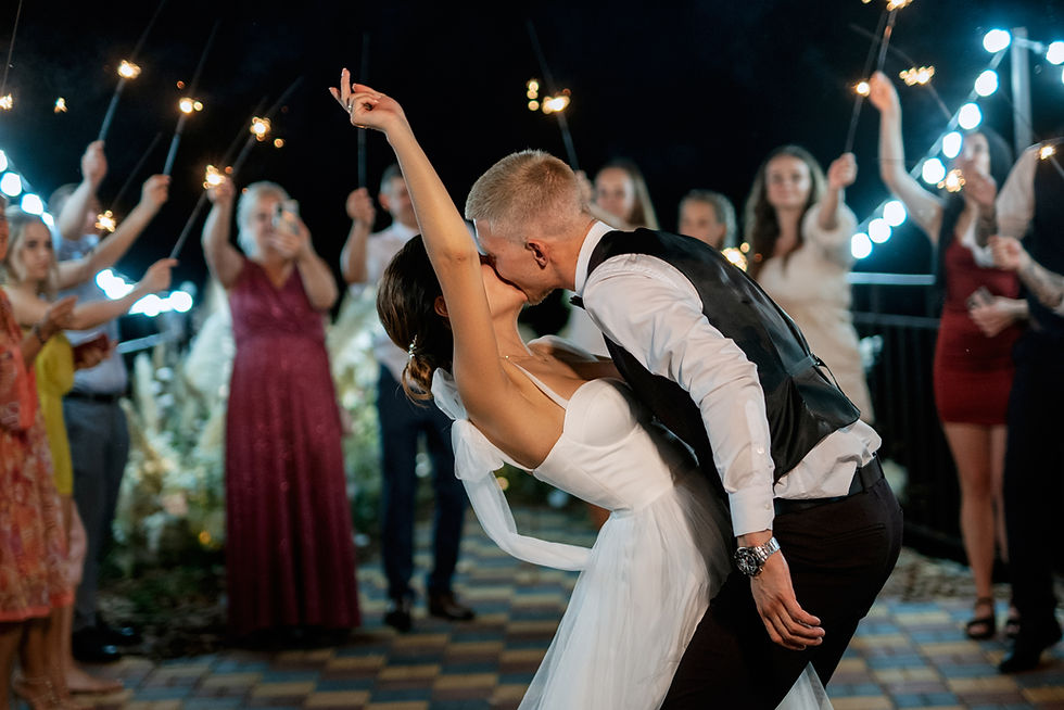 Bride and groom kissing on the dance floor during a sparkler exit at a wedding reception.