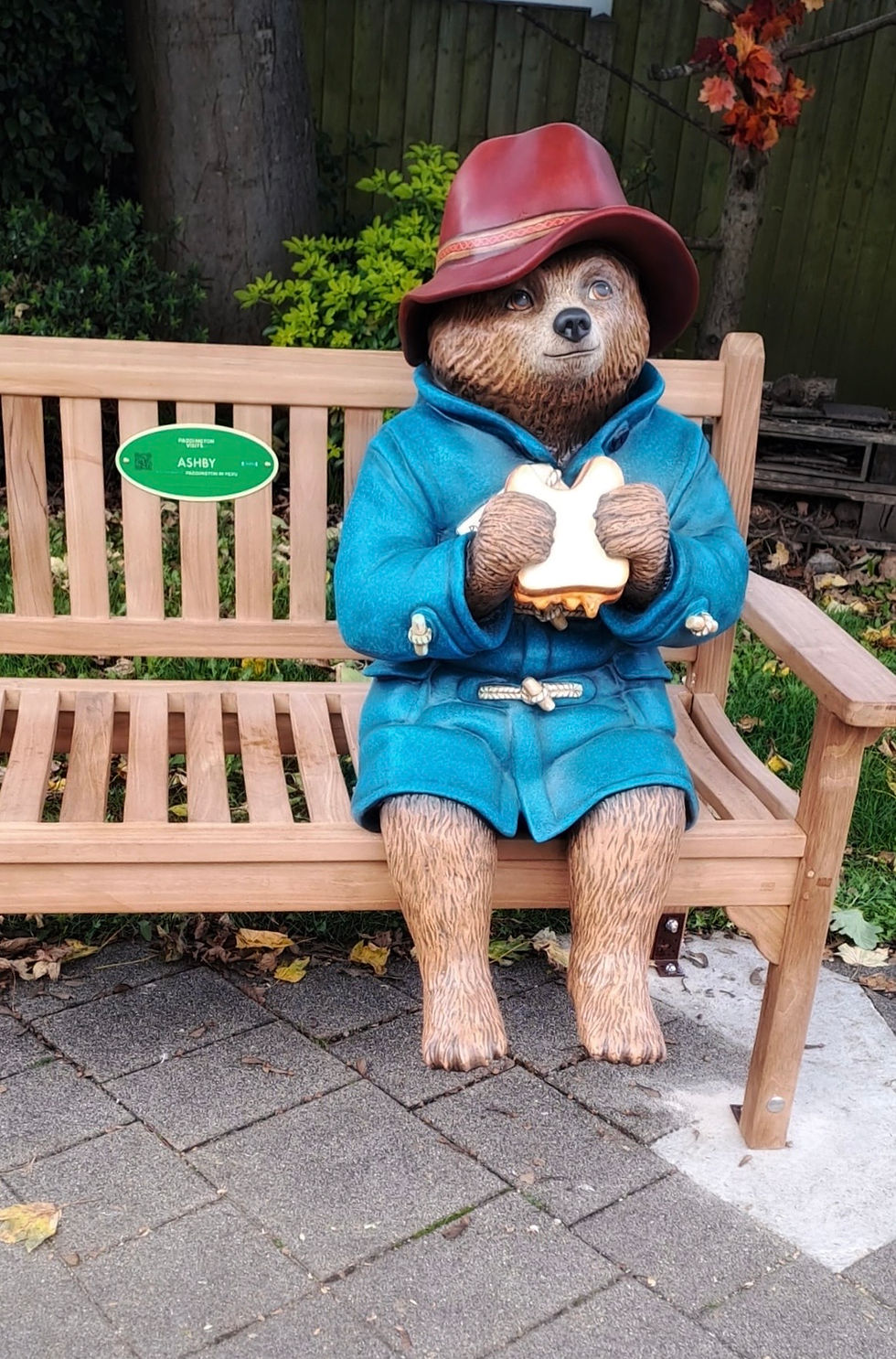 Paddington Bear, eating a marmalade sandwich, whilst sitting on a bench, in Ashby de la Zouch