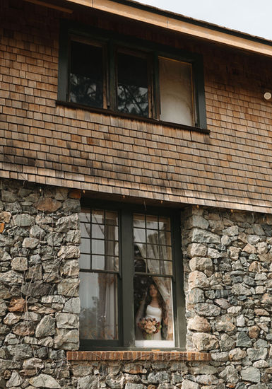 Bride looking out historic window