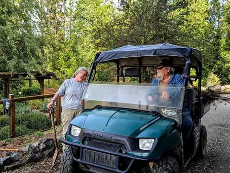 Golf cart in garden with two volunteers