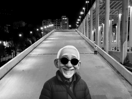 Foto senhor grisalho sorrindo. Ao fundo, rampa de acesso ao estádio. Imagem em preto e branco