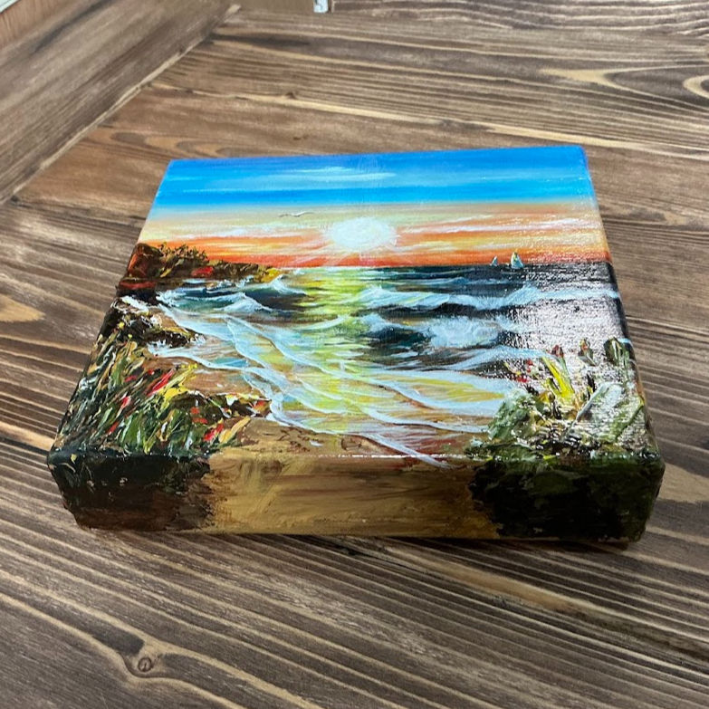 Thumbnail: Acrylic painting of a sunset over the ocean with waves, sailboats, coastal cliffs, and wild beach grass, titled 'I Love You