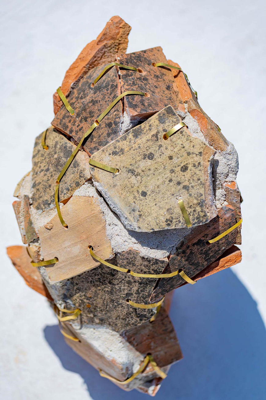 Détail rapproché de l’urne « Vaisseaux_001 », mettant en valeur les fragments de tuile et les attaches en laiton.