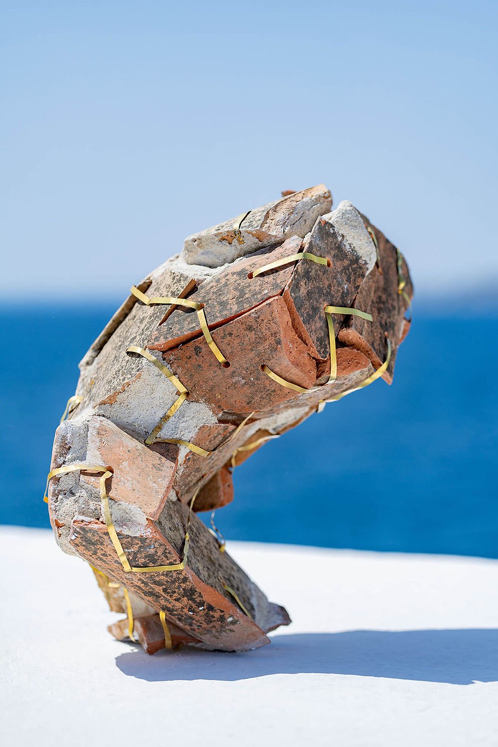 Vue latérale de l’urne cinéraire « Vaisseaux_001 », structure en tuiles recyclées maintenues par du laiton.