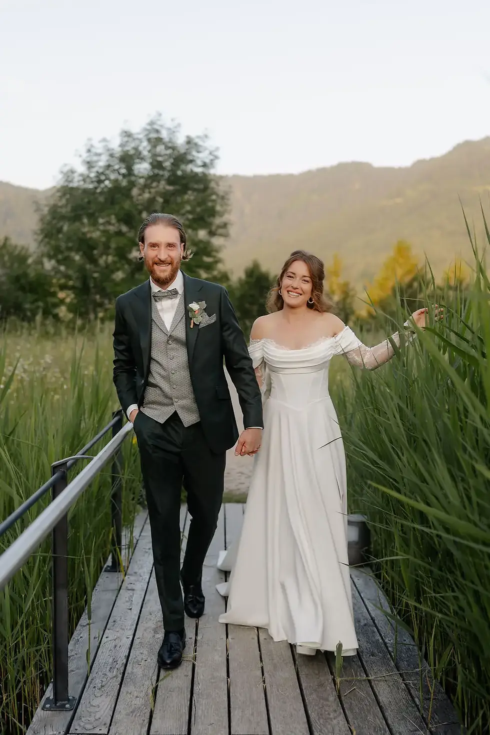 Brautpaar geht ueber Holzsteg Hochzeitsfotograf Kerim Kelmendi Salzbergalm Berchtesgaden