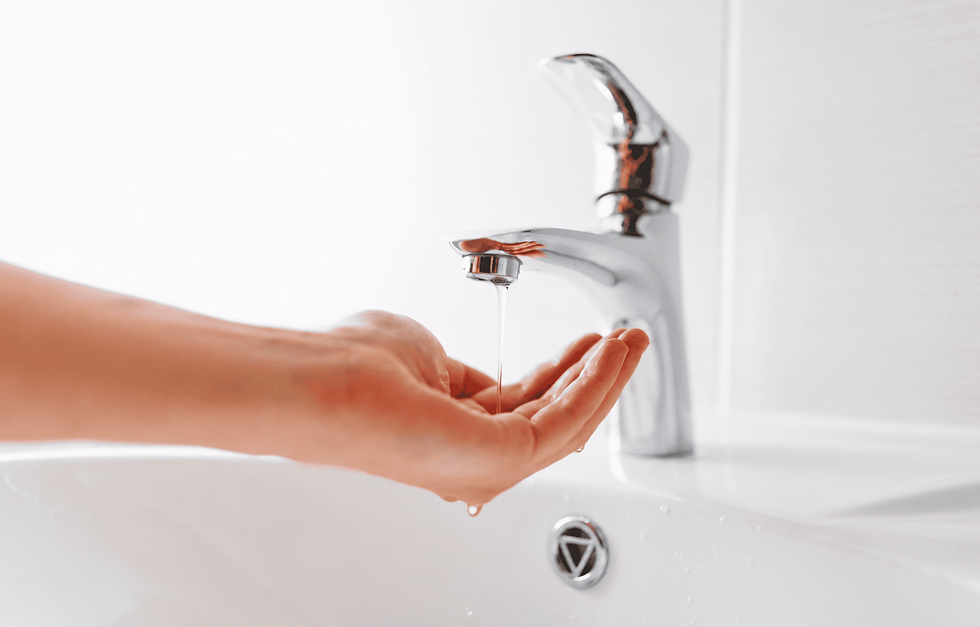 hands catching running water from a modern chrome bathroom faucet