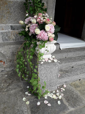 Composizione floreale con ortensie rosa e rose avorio all’ingresso della chiesa per il matrimonio di Carla & Marco, realizzata da Il Fiorista di Mauro Barcellini.
(Floral arrangement with pink hydrangeas and ivory roses at the church entrance for Carla & Marco’s wedding, by Il Fiorista di Mauro Barcellini.)