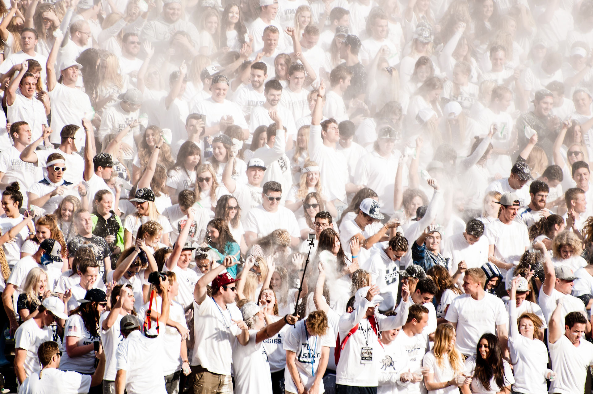 Erin Holmstead Photography Utah State student section cheering wearing all white at a football game