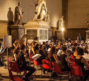 Young orchestra performing under the vaulted arches of the Loggia dei Lanzi, Piazza della Signoria, Florence