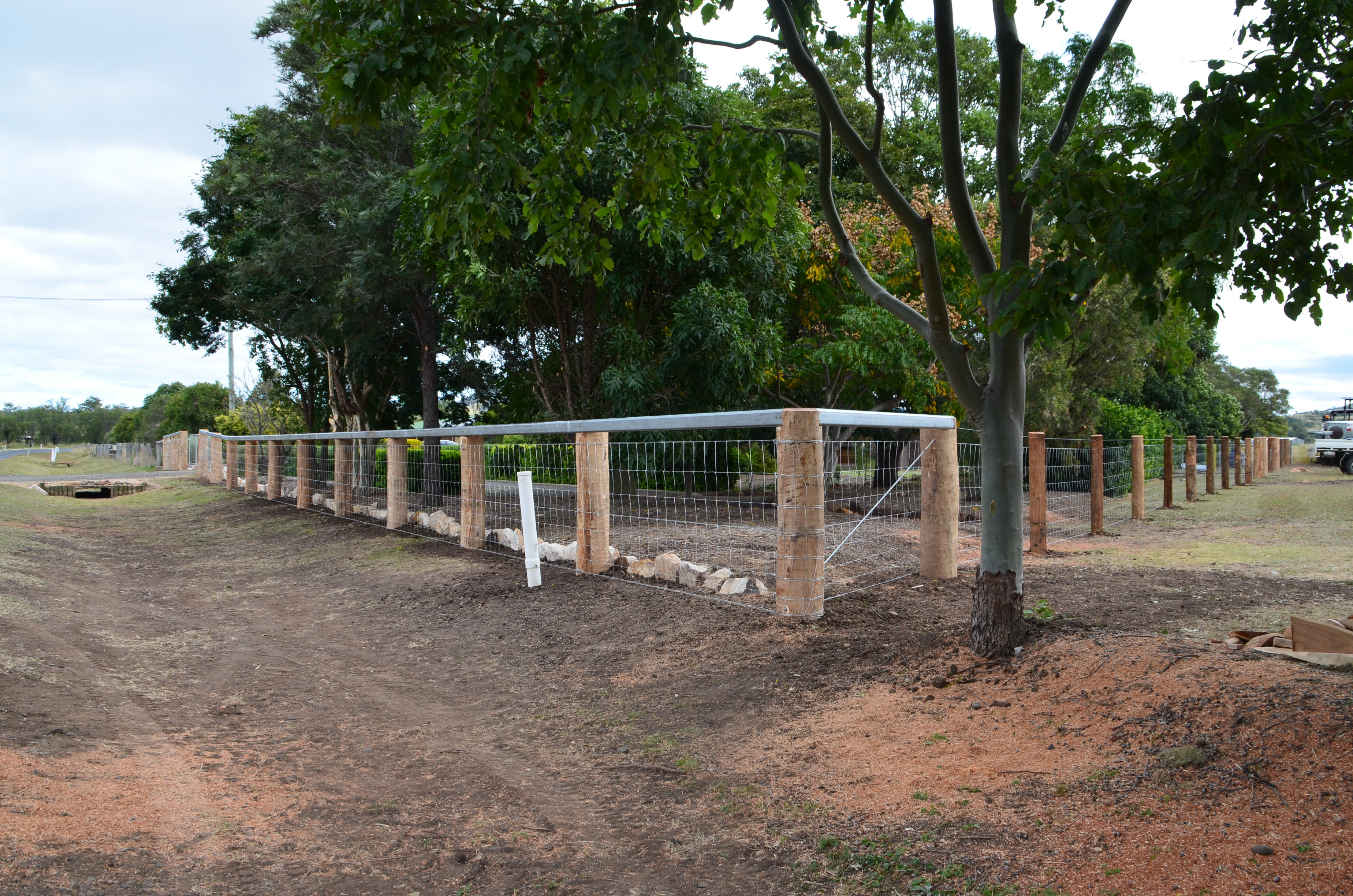 Round posts, cattle rail + dog wire
