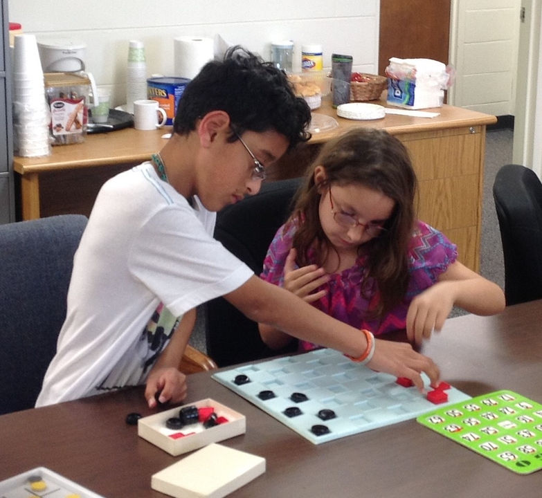 A young boy and girl play a game of checkers