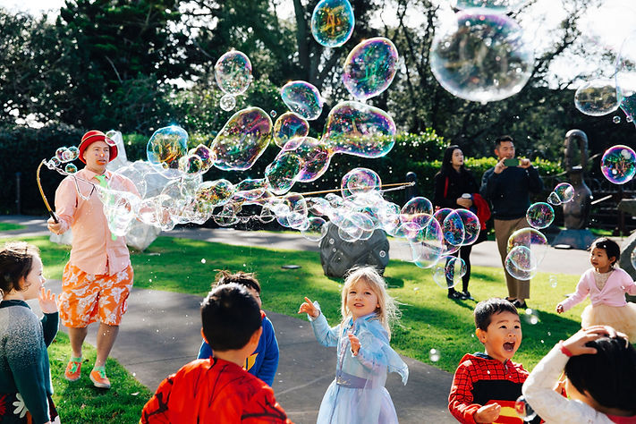 Children playing with giant bubbles in a park