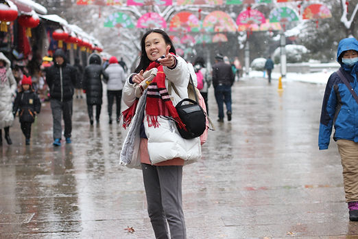 Smiling woman in snowy street, red scarf