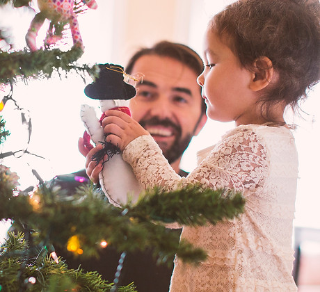 Father and daughter decorating christmas tree