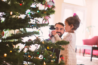Pai e filha que decora a árvore de Natal