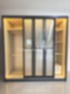 Modern custom closet with sliding glass doors and lighting