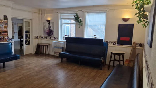 A small but bright room, with couches against the walls.