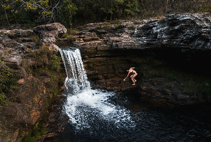 Madá Granja moves cafefully, navigating rocky terrain to reach a waterfall near Alto Paraiso.