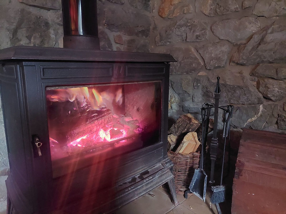 Traditional wood-burning fireplace inside La Hornera bar at Hotel Moto-rural VEGALION in Spain