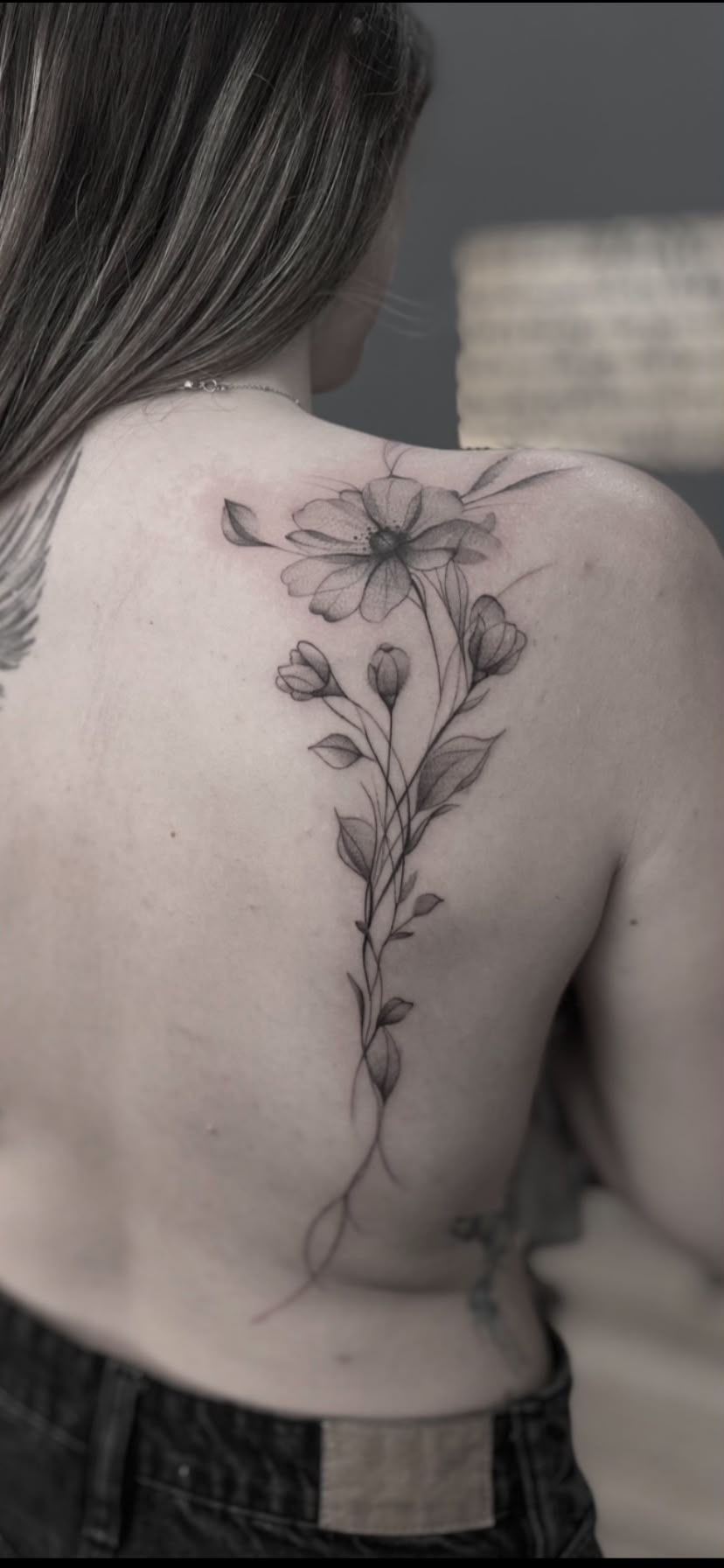Los tatuajes florales para mujer son una de las opciones más elegantes y atemporales para quienes buscan un diseño femenino, delicado y lleno de personalidad. Este espectacular tatuaje de flores en la espalda combina diferentes flores y tallos en una composición vertical que acompaña de forma natural las líneas del cuerpo.